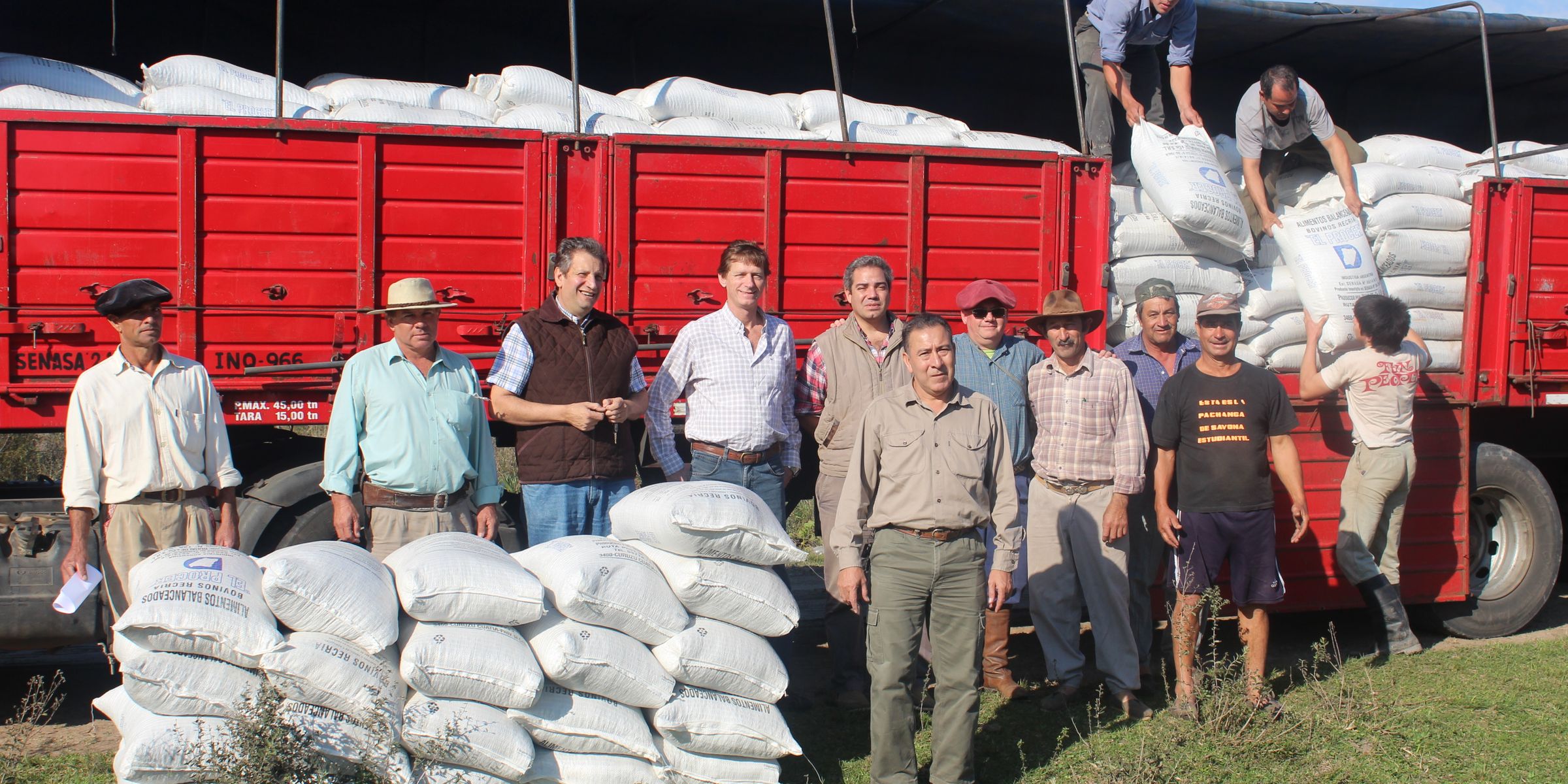 Trabajadores junto a un camión rojo durante una jornada de carga en Argentina